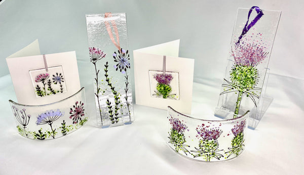 Selection of fused glass decorations ornaments with thistle and wildflower designs in pinks and purples
