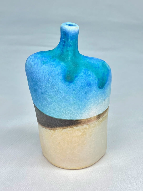 Figurative stoneware bottle with turquoise brown and white glaze in an abstract landscape design