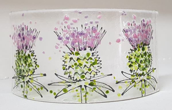 Freestanding curved fused glass panel decorated with thistle design in pinks and purples